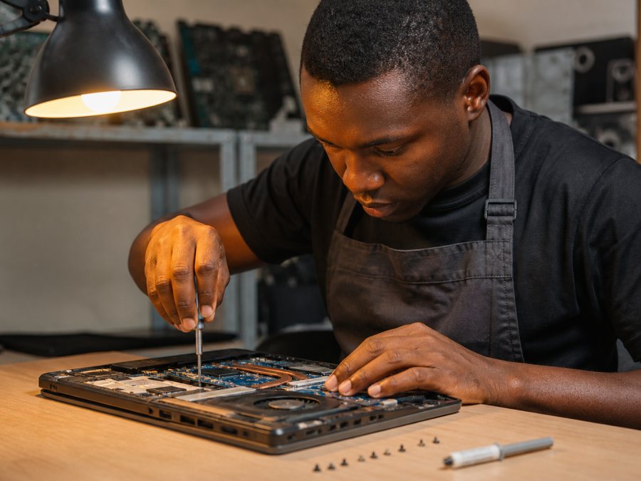 Technician repairing a laptop at a workbench